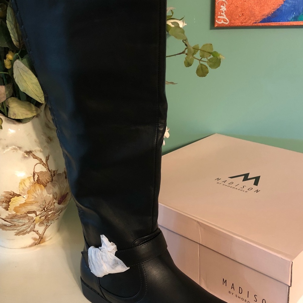Tall black riding style boots.